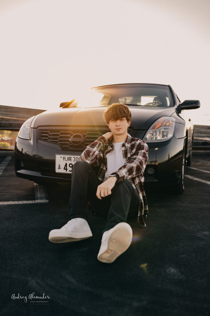 Senior teen boy posing with his car at sunset in Marietta