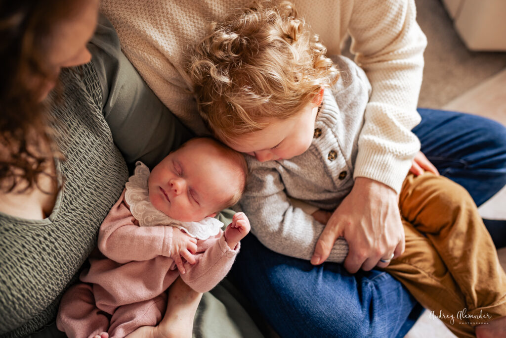 Toddler snuggling with newborn sibling
