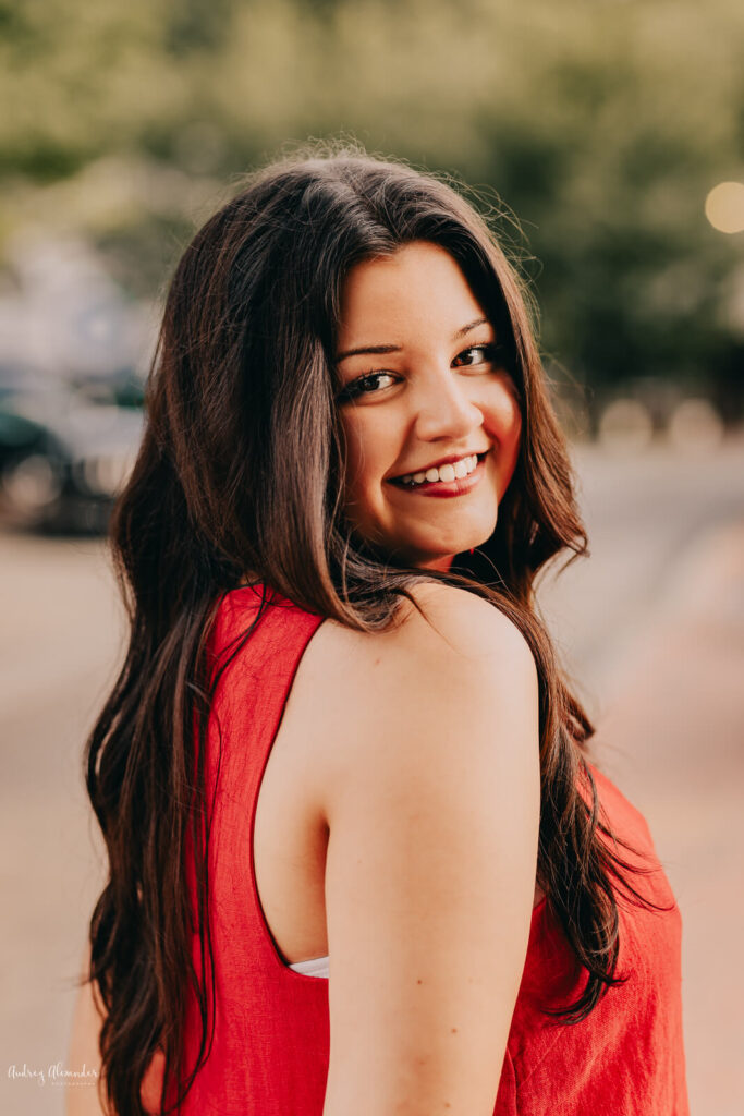 Senior girl smiling with over the shoulder pose in downtown Roswell