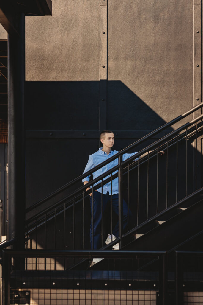 Senior boy on modern urban staircase looking off