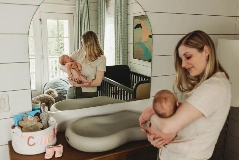 Mom and baby in modern nursery during newborn photo session in Roswell, GA