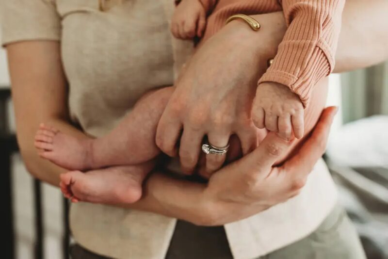 Mom and baby in modern nursery during newborn photo session in Milton, GA