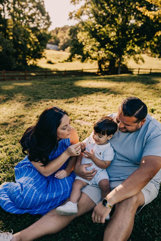 family interacting and smiling with child at beautiful family photo session
