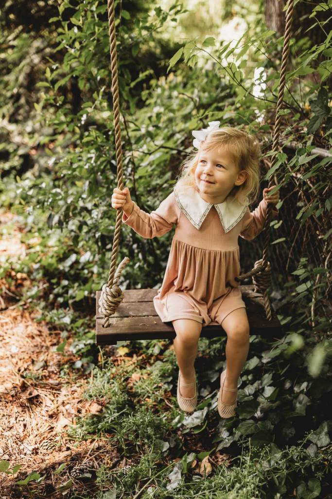 Child portrait on swing smiling at her parents in Roswell GA